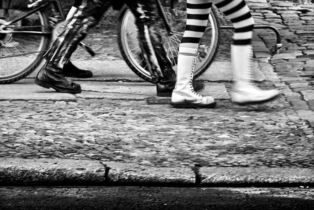 Boots and striped tights beside a bicycle.